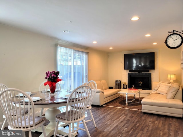 dining area with a fireplace, baseboards, dark wood finished floors, and recessed lighting