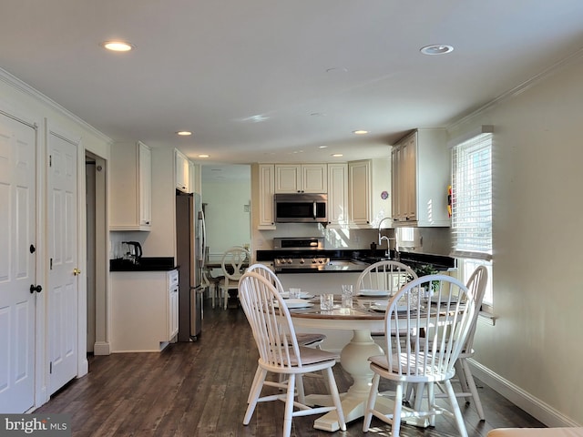 kitchen with recessed lighting, stainless steel appliances, dark wood-type flooring, dark countertops, and crown molding