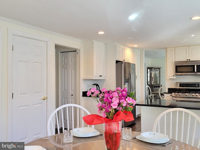 kitchen featuring dark countertops, appliances with stainless steel finishes, crown molding, and recessed lighting