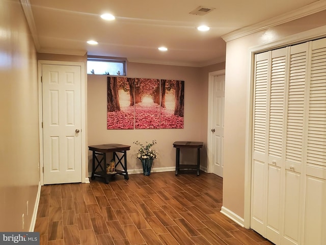 hall with ornamental molding, baseboards, visible vents, and dark wood-type flooring