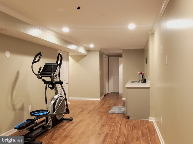 workout room with ornamental molding, recessed lighting, a sink, and light wood-style flooring