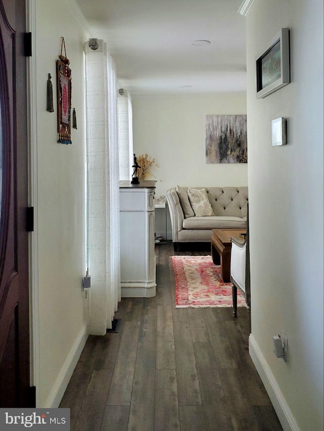 hall featuring dark wood-style flooring and baseboards