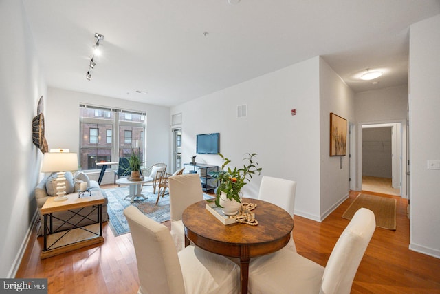 dining room featuring visible vents, baseboards, and wood finished floors