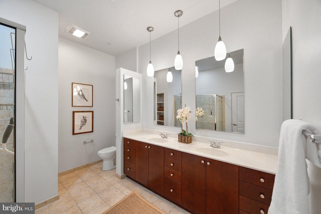 full bathroom featuring toilet, a shower stall, double vanity, and a sink