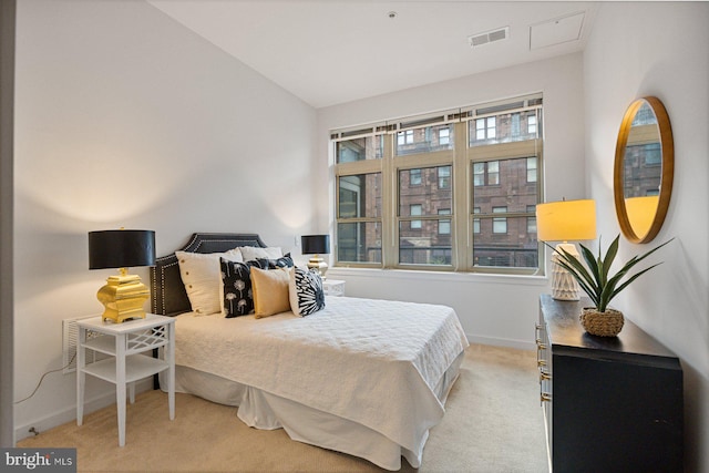 bedroom featuring light carpet, baseboards, visible vents, and lofted ceiling