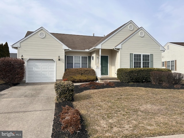 single story home featuring an attached garage, a front lawn, and concrete driveway