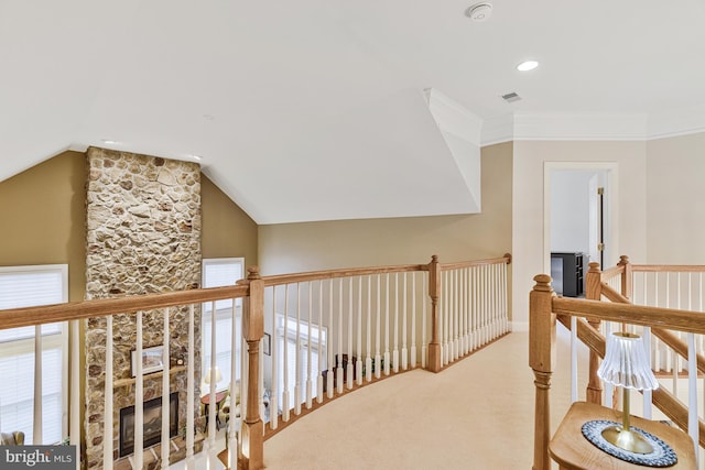 corridor featuring visible vents, an upstairs landing, carpet floors, crown molding, and lofted ceiling