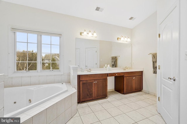 bathroom featuring double vanity, a jetted tub, visible vents, and a sink