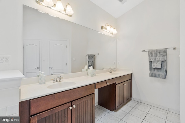 bathroom featuring a sink, vaulted ceiling, double vanity, and tile patterned flooring