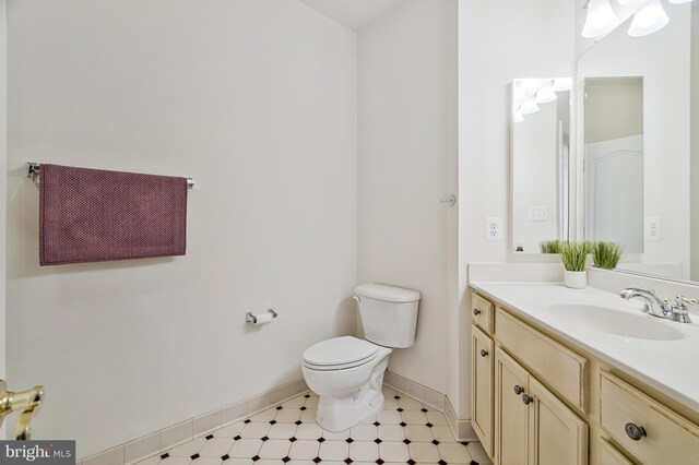 bathroom featuring vanity, toilet, and baseboards