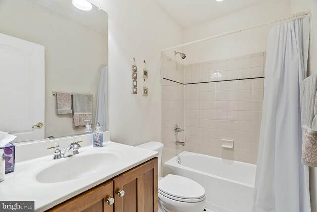 bathroom featuring vanity, shower / tub combo, and toilet