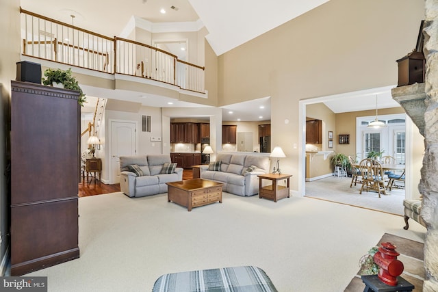 carpeted living area with recessed lighting, visible vents, baseboards, and a towering ceiling