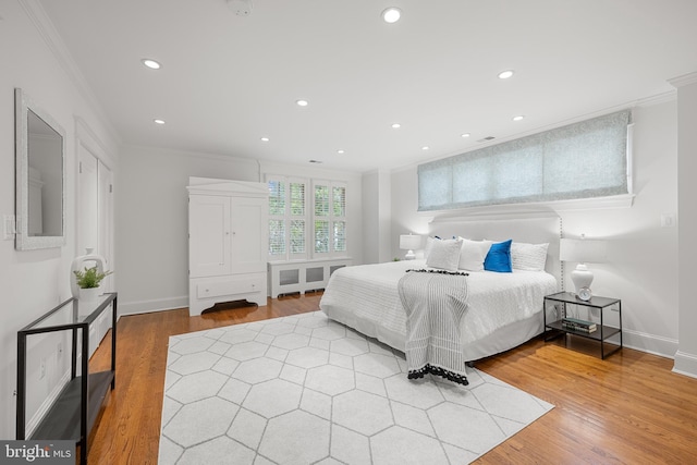 bedroom with light wood-style floors, recessed lighting, crown molding, and baseboards