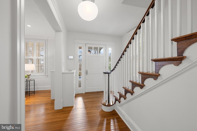 entrance foyer with wood-type flooring, stairway, and baseboards