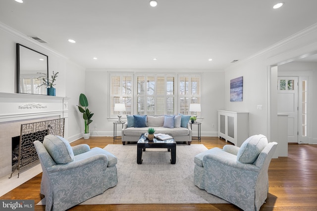 living room featuring visible vents, wood finished floors, and ornamental molding