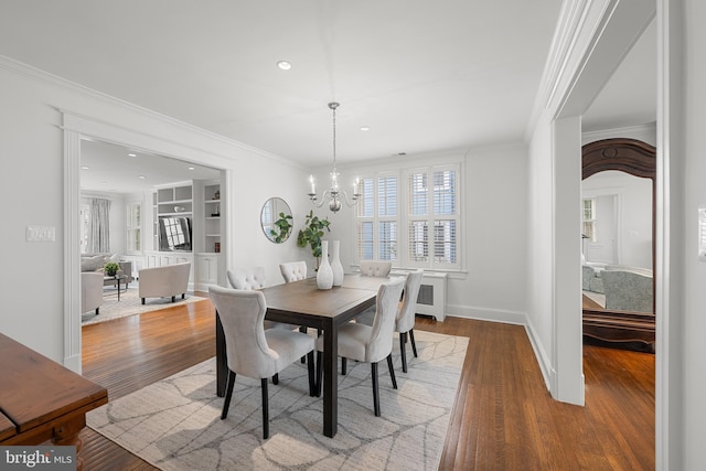 dining space featuring ornamental molding and wood finished floors