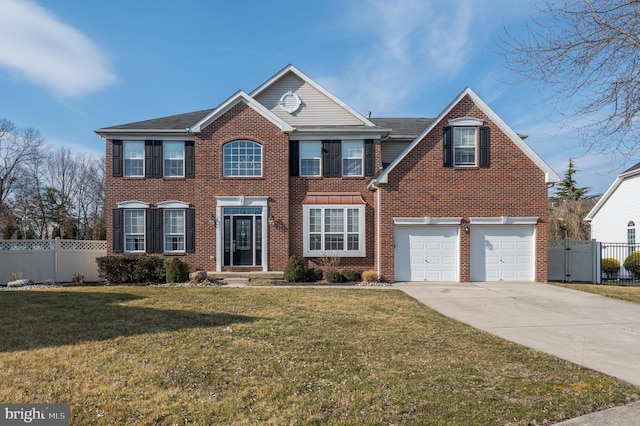 colonial house featuring a front yard, fence, concrete driveway, and brick siding