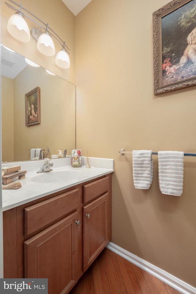 bathroom with wood finished floors, vanity, and baseboards