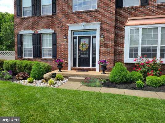 property entrance with a lawn and brick siding