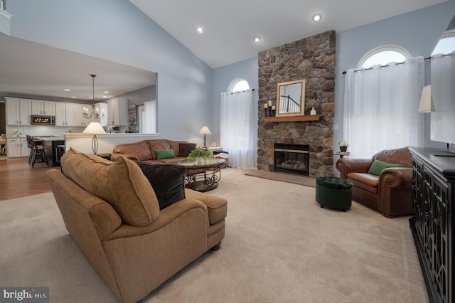 living room featuring light carpet, high vaulted ceiling, a fireplace, and recessed lighting