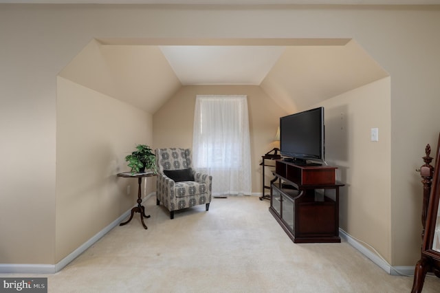 living area with lofted ceiling, baseboards, and carpet flooring