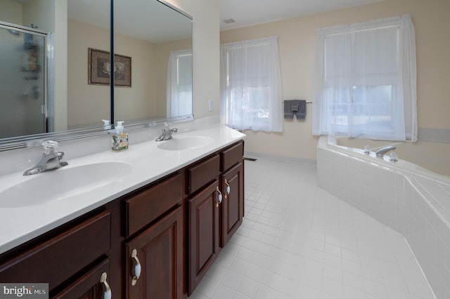 bathroom featuring double vanity, tile patterned flooring, a sink, and a shower stall