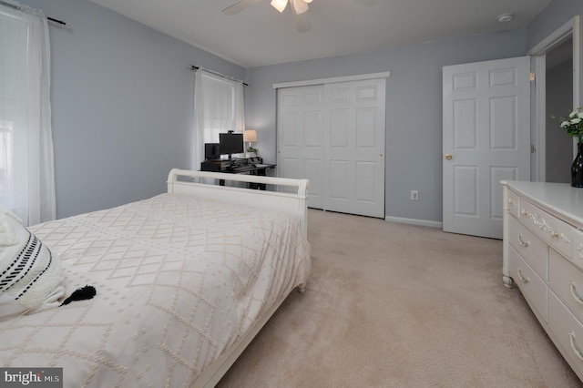 bedroom with ceiling fan, baseboards, a closet, and light colored carpet