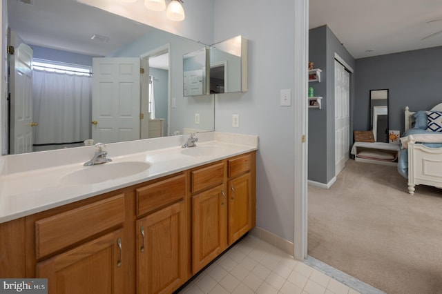 bathroom with double vanity, tile patterned flooring, a sink, and baseboards