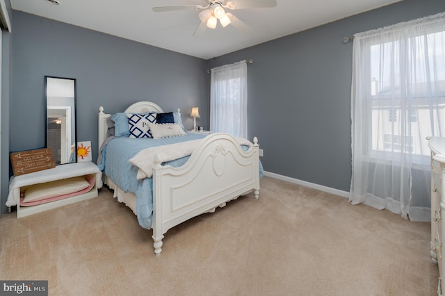 bedroom featuring ceiling fan, baseboards, and light colored carpet