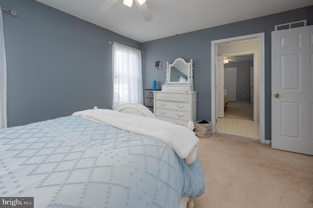 bedroom featuring visible vents, ceiling fan, and light carpet