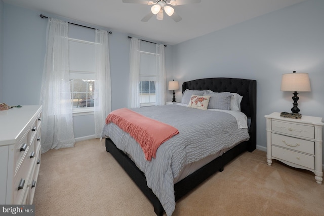 bedroom featuring light carpet, a ceiling fan, and baseboards