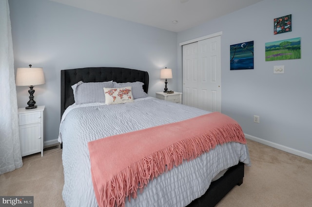 carpeted bedroom with baseboards and a closet