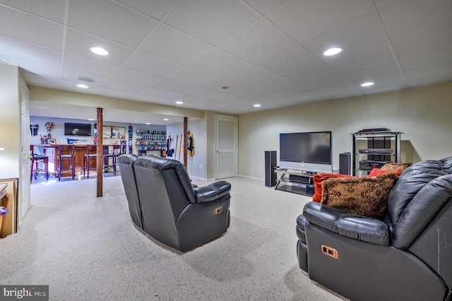 living room with recessed lighting, baseboards, a drop ceiling, and a bar