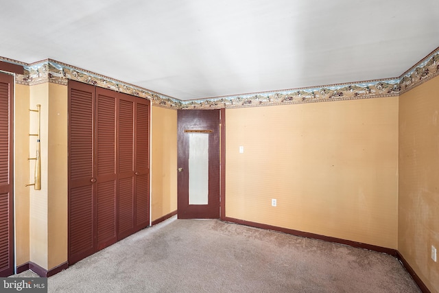 unfurnished bedroom with a closet, carpet flooring, and baseboards