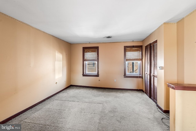 carpeted empty room featuring baseboards