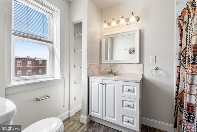 full bathroom with toilet, tasteful backsplash, wood finished floors, and a wealth of natural light