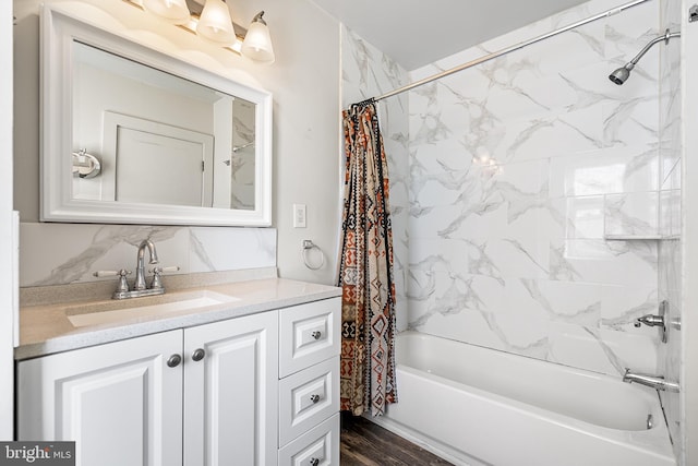 bathroom with shower / tub combo with curtain, vanity, decorative backsplash, and wood finished floors