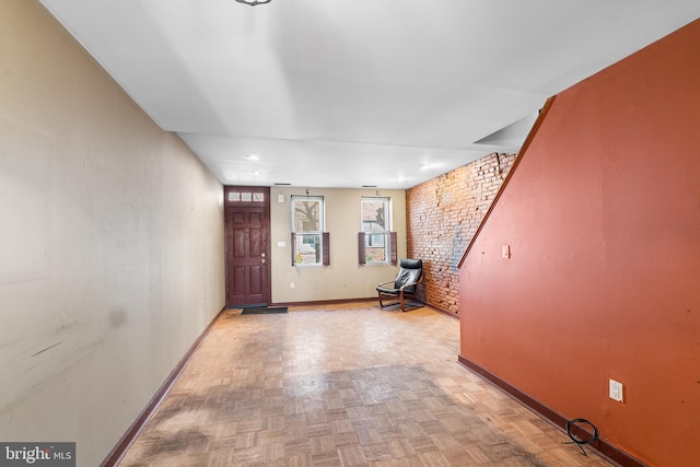 entrance foyer with brick wall and baseboards