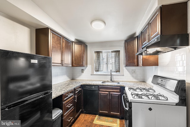 kitchen featuring tasteful backsplash, dark wood-type flooring, under cabinet range hood, black appliances, and a sink