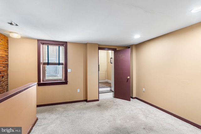 empty room featuring light carpet and baseboards