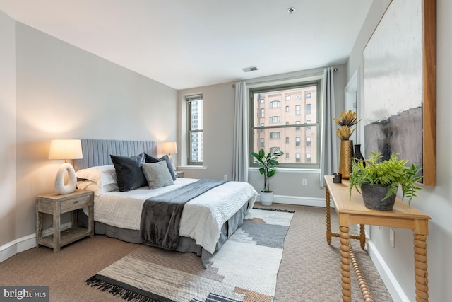 bedroom with carpet floors, visible vents, and baseboards