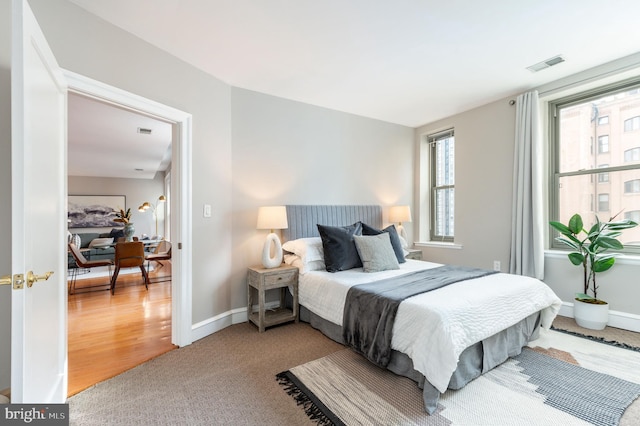 bedroom with baseboards and visible vents