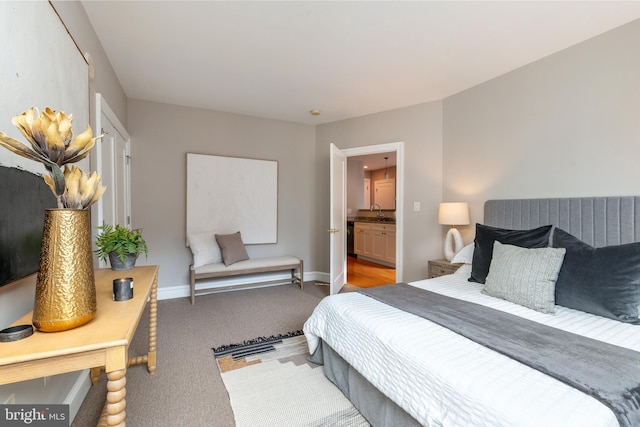 bedroom with a sink, baseboards, and carpet flooring