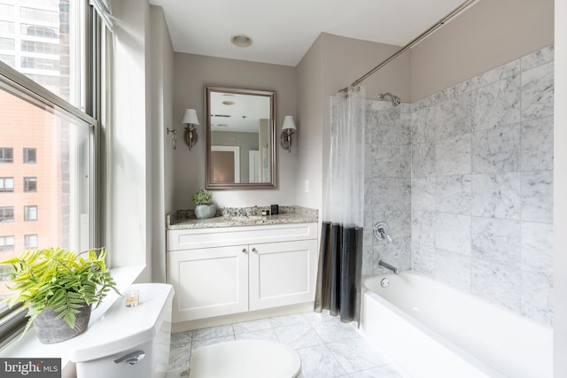 bathroom featuring toilet, shower / bath combo with shower curtain, and vanity