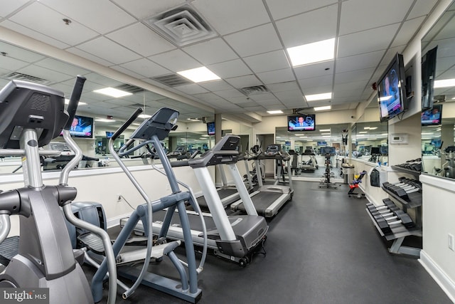 gym with a drop ceiling, visible vents, and baseboards