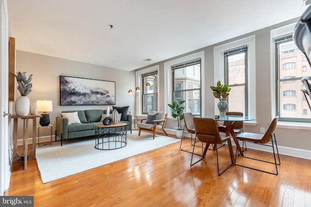 living room with light wood-type flooring and baseboards