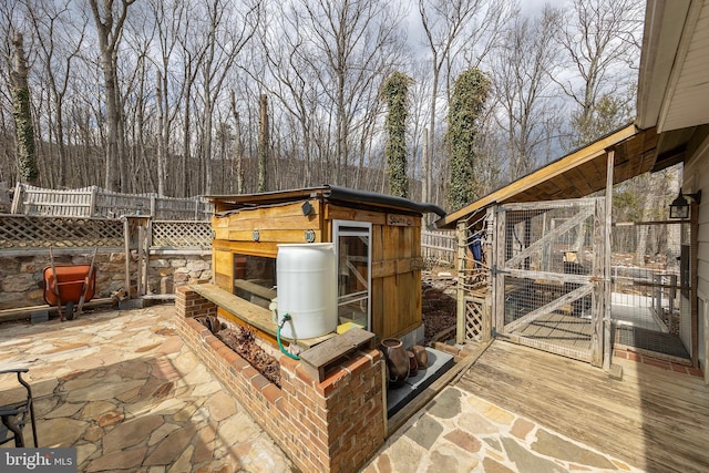 view of patio with an outdoor structure and fence