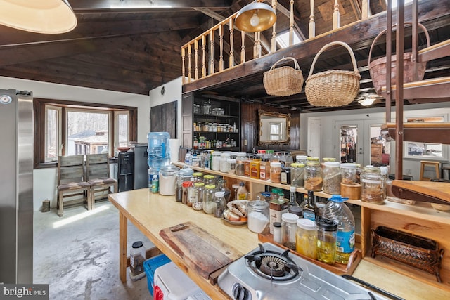 kitchen with freestanding refrigerator, french doors, vaulted ceiling, and unfinished concrete flooring