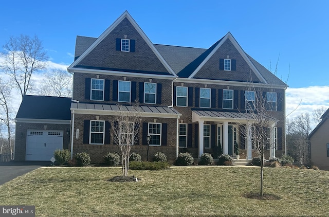 view of front facade featuring an attached garage, brick siding, driveway, a standing seam roof, and a front yard