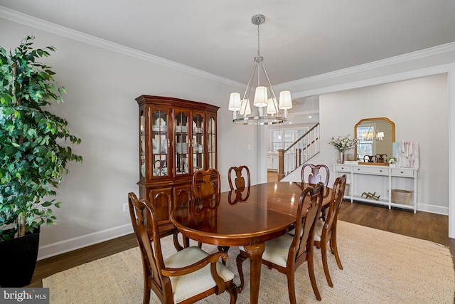 dining space featuring crown molding, baseboards, wood finished floors, and a notable chandelier